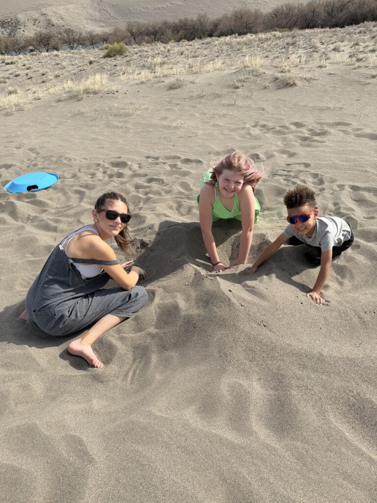 kids playing and climbing sand dunes at Bruneau Sand Dunes Idaho