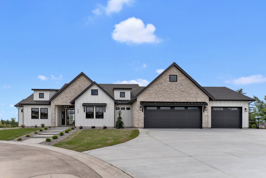 Front exterior of a Treasure Valley home with a three-car garage on a clear day