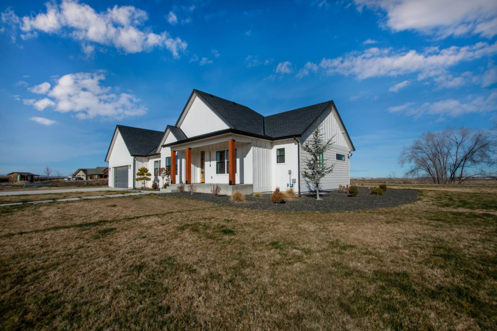 Front exterior of a farmhouse-style Treasure Valley home on an open lot